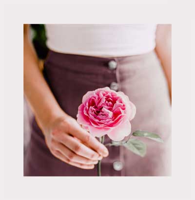 woman holding a rose on a blurred background