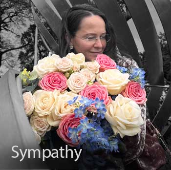 Bouquet of flowers held by a person with pink, white and blue flowers