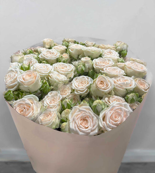 Bouquet of spray white roses wrapped in kraft paper